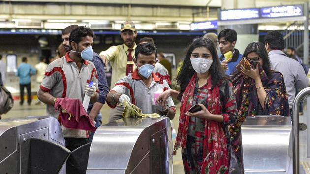 Workers clean entry gates at Rajeev Chowk metro station in the wake of novel coronavirus (COVID-19) outbreak, in New Delhi (PTI)