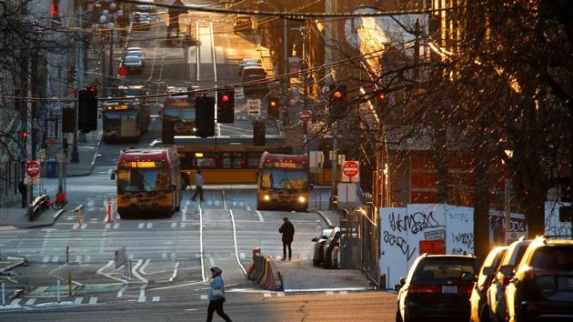 Coronavirus outbreak: A person crosses the street in the International District-Chinatown neighborhood during the outbreak of coronavirus disease (COVID-19), in Seattle, Washington, U.S.(REUTERS)