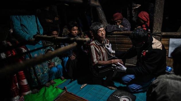 Medical Action Myanmar (MAM) doctor Zaw Min Lay (R) treats a member of a Naga tribe at a mobile clinic. Mon’s six-year-old son, Mg Taing Khite, is one of about 300 such cases in the area, his legs so bowed and painful, he was unable to walk just a few months ago. Thanks to a course of vitamin D and calcium supplements, Mg Taing Khite now cavorts around with the village’s other kids. (Ye Aung Thu / AFP)