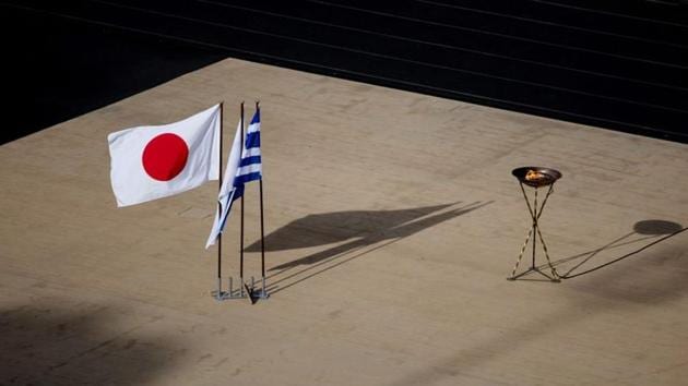 The Japanese national flag waves next to an altar with the Olympic flame of the Tokyo 2020 Summer Olympics(REUTERS)