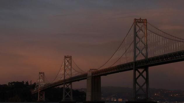 A woman walks along the Embarcadero in front of the San Francisco-Oakland Bay Bridge in San Francisco. (AP) A woman walks along the Embarcadero in front of the San Francisco-Oakland Bay Bridge in San Francisco. (AP)