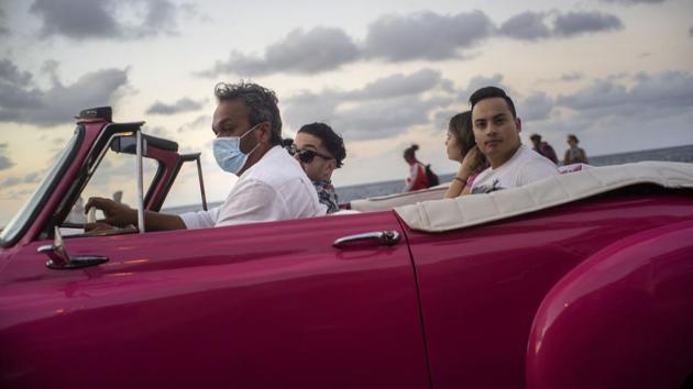 A taxi driver, wearing a protective mask as a precaution drives his American classic car with tourists in Havana, Cuba. For most people, the new coronavirus has caused only mild or moderate symptoms, such as fever and cough. Cuba said Monday it would allow a British cruise ship to dock with five people aboard infected with the coronavirus and nearly 40 others in isolation with flu-like symptoms. (Ramon Espinosa / AP) A taxi driver, wearing a protective mask as a precaution drives his American classic car with tourists in Havana, Cuba. For most people, the new coronavirus has caused only mild or moderate symptoms, such as fever and cough. Cuba said Monday it would allow a British cruise ship to dock with five people aboard infected with the coronavirus and nearly 40 others in isolation with flu-like symptoms. (Ramon Espinosa / AP)