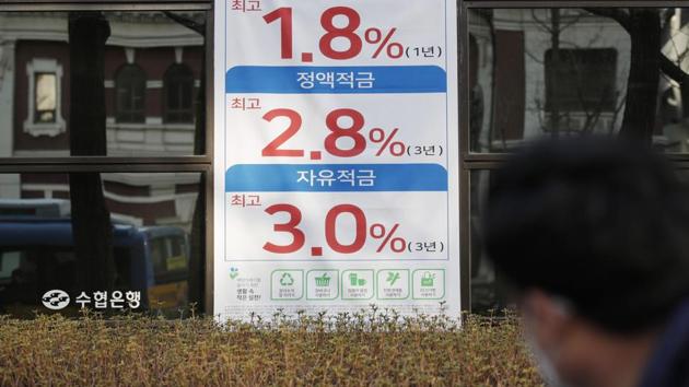 A man wearing a face mask passes by an advertisement showing bank's interest rates during the coronavirus outbreak in Seoul, South Korea. (AP)