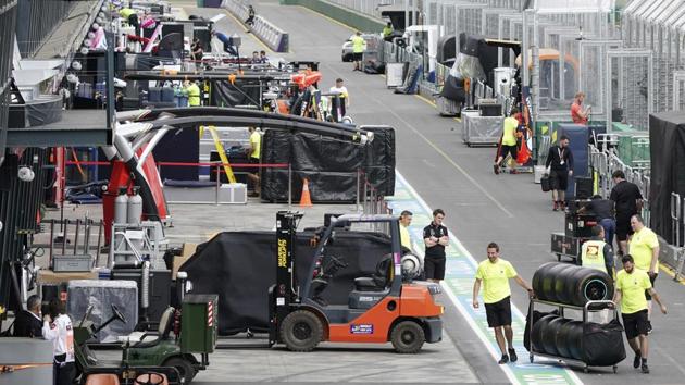 Workers pack up in pit lane after the cancellation of the Australian Formula One Grand Prix in Melbourne. (AP) Workers pack up in pit lane after the cancellation of the Australian Formula One Grand Prix in Melbourne. (AP)