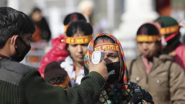 An official uses a thermal screening device on devotees as coronavirus pandemic spreads in India, at Vaishno Devi on Friday.(PTI Photo)
