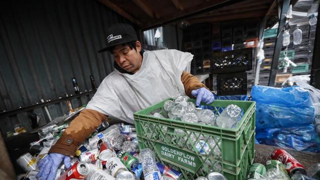Pedro Galicia organizes his haul of cans and bottles for redemption at the Sure We Can, a Brooklyn non-profit redemption center.(AP) Pedro Galicia organizes his haul of cans and bottles for redemption at the Sure We Can, a Brooklyn non-profit redemption center.(AP)