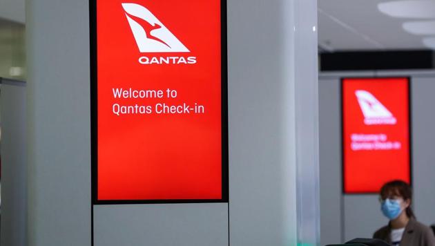 A passenger wearing a protective mask waits at the Qantas Airways Ltd. check-in counters at Sydney Airport in Sydney, Australia, on Tuesday, March 17, 2020. (Bloomberg) A passenger wearing a protective mask waits at the Qantas Airways Ltd. check-in counters at Sydney Airport in Sydney, Australia, on Tuesday, March 17, 2020. (Bloomberg)