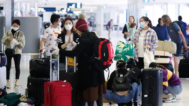 Passengers wearing protective masks wait in line to check-in at Sydney Airport in Sydney, Australia, on Tuesday. (Bloomberg Photo) Passengers wearing protective masks wait in line to check-in at Sydney Airport in Sydney, Australia, on Tuesday. (Bloomberg Photo)