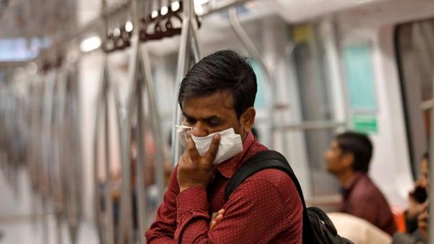 A commuter uses his handkerchief to cover his face as he travels in a metro amid coronavirus fears, in New Delhi on March 17.(Reuters Photo) A commuter uses his handkerchief to cover his face as he travels in a metro amid coronavirus fears, in New Delhi on March 17.(Reuters Photo)