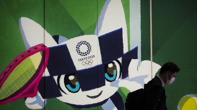 A pedestrian walks past a large display promoting the Tokyo 2020 Olympics in Tokyo (AP) A pedestrian walks past a large display promoting the Tokyo 2020 Olympics in Tokyo (AP)