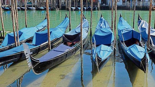 Gondolas seen lined up in a canal in Venice, Italy due to a complete tourism shutdown, on Wednesday.(Reuters)