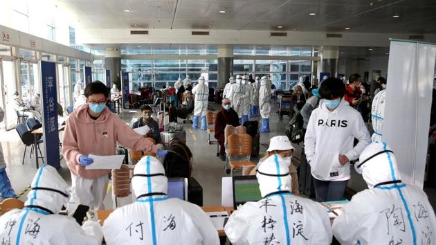 Passengers register their information at the New China International Exhibition Center, a transit hub to screen incoming passengers from the Beijing Capital International Airport for Covid-19, in Beijing on March 18.(Reuters Photo)