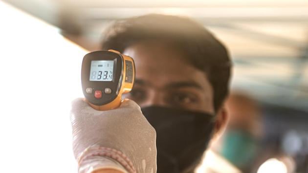 A medical official checks the temperature of passengers who traveling by train in Maharashtra. (Satish Bate/HT Photo) A medical official checks the temperature of passengers who traveling by train in Maharashtra. (Satish Bate/HT Photo)