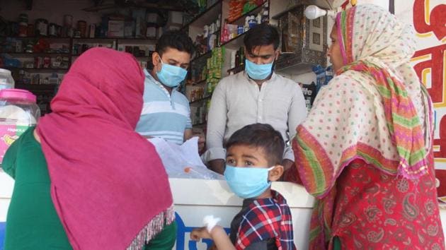 Shopkeepers wearing face masks attend to customers outside the SGT Hospital in Budhera where a coronavirus quarantine ward has been set up, in Gurugram. (Yogendra Kumar/HT PHOTO) Shopkeepers wearing face masks attend to customers outside the SGT Hospital in Budhera where a coronavirus quarantine ward has been set up, in Gurugram. (Yogendra Kumar/HT PHOTO)