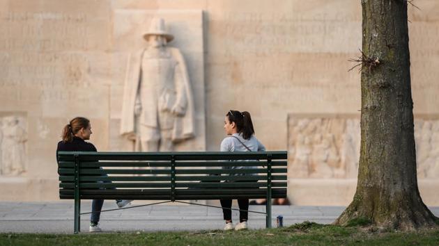 Women speak to each other while maintaining social distance on a bench next to the Reformation Wall in Geneva. In wake of the COVID-19, the concept of respecting personal space around the world has been redefined. (Fabrice Coffrini / AFP)