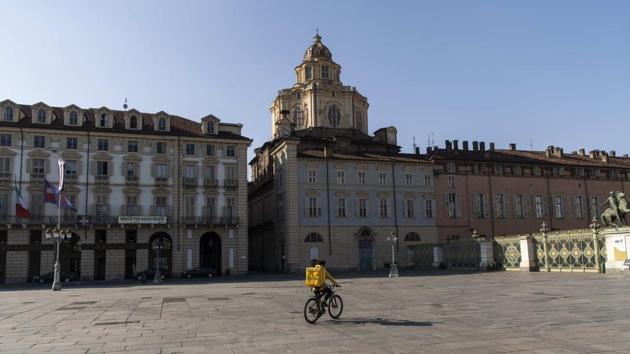 A food delivery rider pedals in deserted Piazza Castello, in Turin, Italy, Thursday, March 19, 2020. Ital y has now overtaken China in the number of coronavirus deaths. (AP) A food delivery rider pedals in deserted Piazza Castello, in Turin, Italy, Thursday, March 19, 2020. Ital y has now overtaken China in the number of coronavirus deaths. (AP)