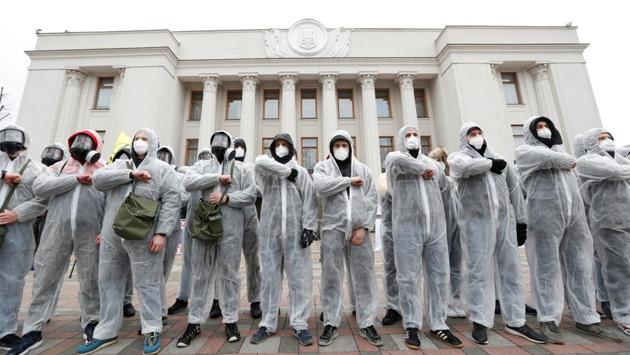 Activists of the National Corps political party are seen wearing protective gear as they take part in a rally demanding to quarantine lawmakers amid coronavirus (COVID-19) concerns, in front of the Ukrainian parliament building in Kiev. (Valentyn Ogirenko / REUTERS) Activists of the National Corps political party are seen wearing protective gear as they take part in a rally demanding to quarantine lawmakers amid coronavirus (COVID-19) concerns, in front of the Ukrainian parliament building in Kiev. (Valentyn Ogirenko / REUTERS)