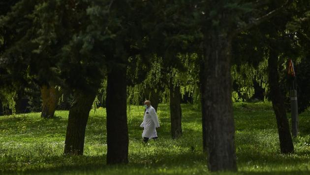 A member of the health service at Txagorritxu hospital walks along the perimeter of the hospital in Vitoria, Spain. Spain will mobilize 200 billion euros or equivalent to one fifth of the country’s annual output in loans, credit guarantees and subsidies for workers and vulnerable citizens, Prime Minister Pedro Sanchez announced Tuesday. (Alvaro Barrientos / AP)