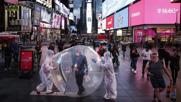 Artists perform under a billboard displaying thanks to health care workers due to COVID-19 concerns in a sparsely populated Times Square, in New York. (AP / PTI)