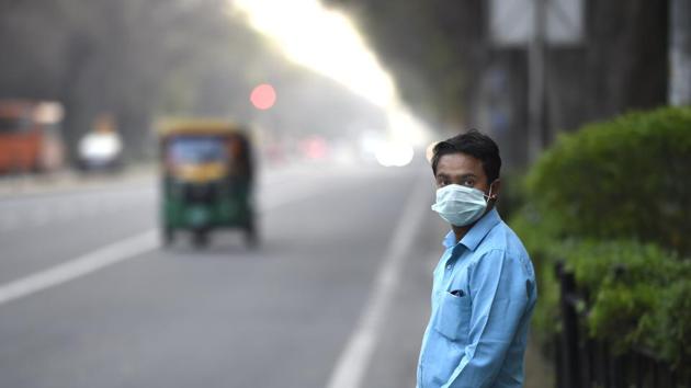 A man wearing a face mask among barely any cars or other vehicular traffic on Tilak Marg as people keep away due to coronavirus concerns, in New Delhi.(Arvind Yadav/HT PHOTO)