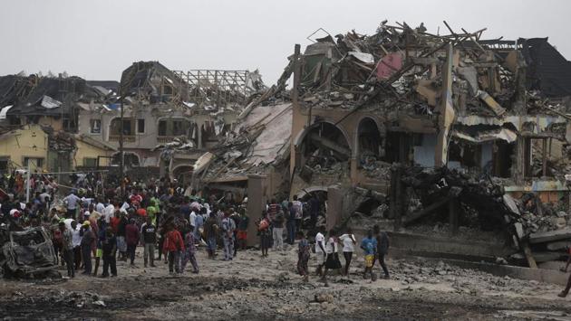 People gather near the site of an explosion in Lagos. An explosion hit Nigeria’s commercial capital of Lagos early Sunday, killing more than a dozen people. (AP / PTI)
