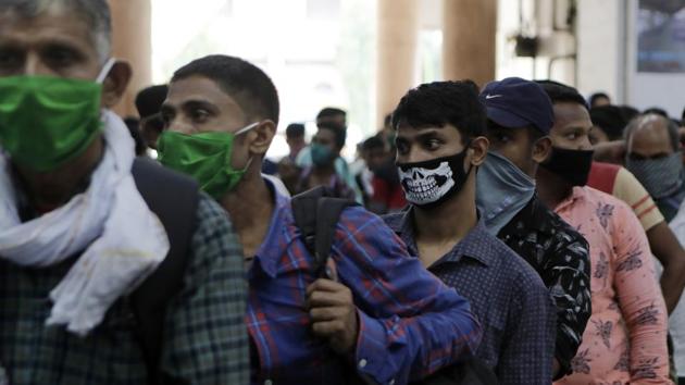 Indians wear face masks as a precaution against COVID-19 line up to buy long distance train tickets at Chhatrapati Shivaji Terminus in Mumbai.(AP)