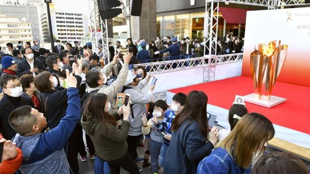 People gather to take a look at Olympic flame on display in Sendai. (AP) People gather to take a look at Olympic flame on display in Sendai. (AP)
