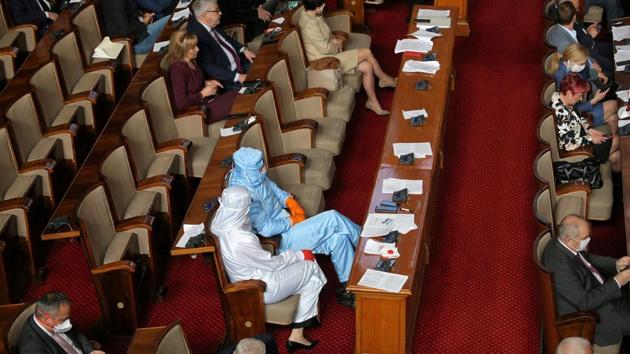 Veselin Mareshki, leader of Bulgarian party Volya (Will), and a deputy from his party wear protective suits during a debate in the parliament in Sofia. (Dimitar Kyosemarliev / REUTERS)