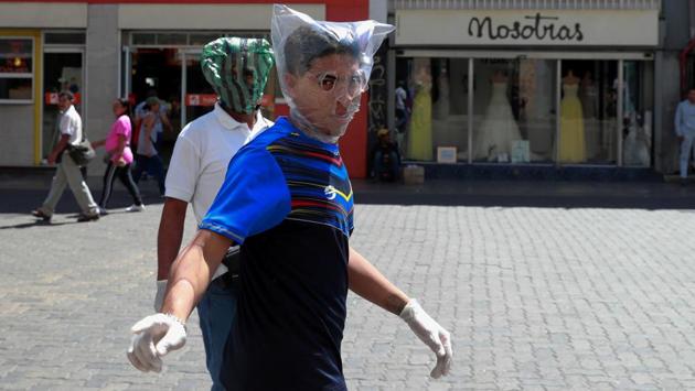 Men cover their faces with plastic bags in response to the spreading coronavirus in Caracas, Venezuela. (Carlos Jasso / REUTERS)