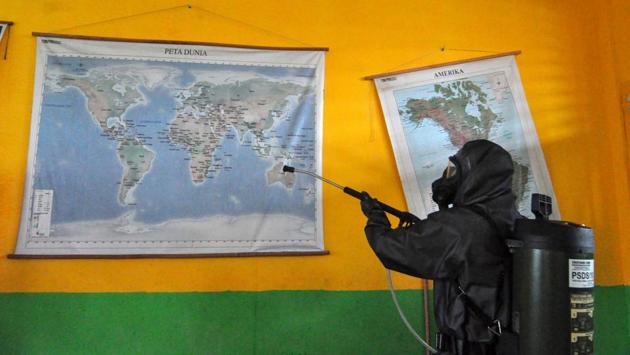 An Indonesian police sprays disinfectant at a local school in Palu, Central Sulawesi amid concerns of the coronavirus outbreak. (Muhammad Rifki / AFP)