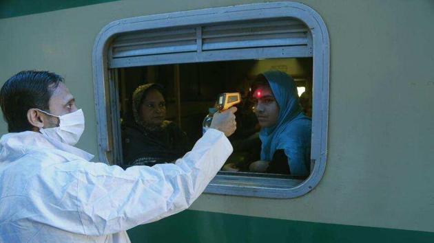 A Pakistani volunteer checks the body temperature of a passenger to help detect coronavirus, at a railway station in Lahore, on March 18. (AP Photo) A Pakistani volunteer checks the body temperature of a passenger to help detect coronavirus, at a railway station in Lahore, on March 18. (AP Photo)
