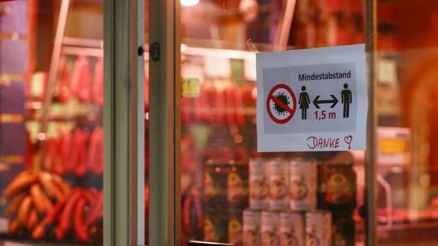 A sign hangs in the window of a butcher shop explaining a minimum distancing rule between the customer and the vendor in Munich, Germany. Germany may impose a nationwide lockdown in the coming days as Bavaria became the first state in the country to enforce severe restrictions on citizens in an effort to stem the spread of the coronavirus.(Bloomberg)