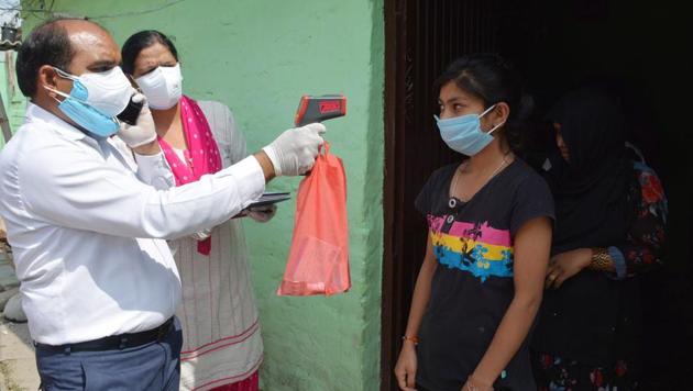 Health department officials screening residents with thermal scanners at Kharak Mangoli village in Panchkula after a positive case was reported in the locality on Saturday. (Sant Arora/HT) Health department officials screening residents with thermal scanners at Kharak Mangoli village in Panchkula after a positive case was reported in the locality on Saturday. (Sant Arora/HT)