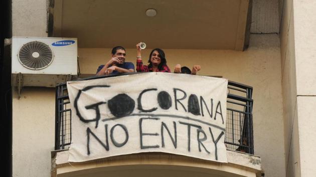 Residents across various condominiums came out in their respective balconies and sang songs to thank people employed in essential services who were working through the pandemic. At Hamilton Court, residents clapped, sang, and held banners stating “Go Corona, No Entry” in Gurugram, India, on Sunday, March 22, 2020. (Parveen Kumar / HT Photo)