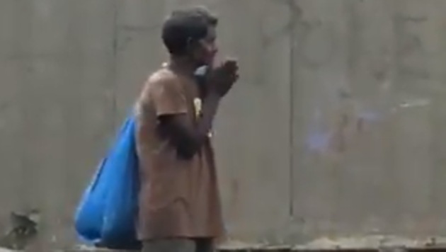 The video shows a man with bag standing on the side of the road clapping his hands.(Twitter/@virendersehwag)
