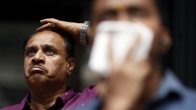A man reacts as he looks at a screen displaying the Sensex results on the facade of the Bombay Stock Exchange (BSE) building in Mumbai. (REUTERS/Francis Mascarenhas/Files)