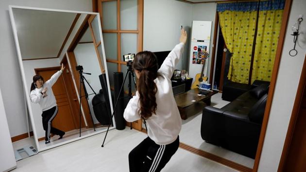 Kim Myung-hae, 46, a pre-school teacher, practices a dance by the South Korean boyband BTS as she watches a YouTube video at her home, during the novel coronavirus disease (COVID-19) outbreak, in Gumi, Gyeongsang Province, South Korea. Kim has been self-isolating since the end of February. “Since I can’t go outside, I do a lot of online shopping. I surf the internet a lot too... I tend to watch a lot of YouTube,” Kim said. (REUTERS / Kim Kyung-Hoon )