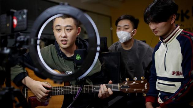 Musicians from the Chinese group "The 2econd" Zhang Cheng, Zhuang Fei and Wen Zheng, perform for their fans during a live-streaming session broadcast on the video sharing website Bilibili at an office in Beijing, China, March 14, 2020. "I see this period as a double-edged sword. Although some performance plans have been postponed, it gave us more time to cool down and reflect on our work and to make it more mature," said Cheng. (Thomas Peter / REUTERS)