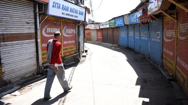 A man walks past the closed lower bazaar market in Shimla on Monday. (Deepak Sansta/HT) A man walks past the closed lower bazaar market in Shimla on Monday. (Deepak Sansta/HT)