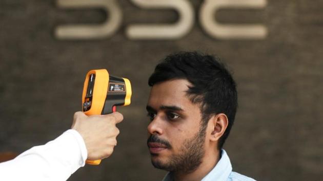 A security official scans a visitor with an infrared thermometer to check his temperature as a precautionary measure against coronavirus outside the Bombay Stock Exchange (BSE) in Mumbai. (REUTERS/Francis Mascarenhas/Files)