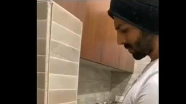 Kartik Aaryan washes his utensils at home.