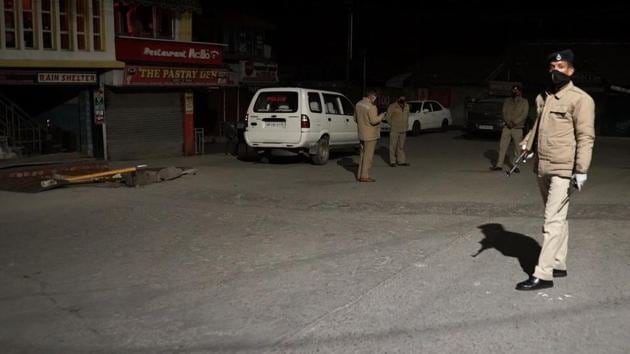 Police personnel patrolling a street in McLeodganj on Monday night. A total lockdown was imposed in the hill town after a Tibetan man died of Covid-19, the first coronavirus death in Himachal Pradesh. (HT Photo) Police personnel patrolling a street in McLeodganj on Monday night. A total lockdown was imposed in the hill town after a Tibetan man died of Covid-19, the first coronavirus death in Himachal Pradesh. (HT Photo)