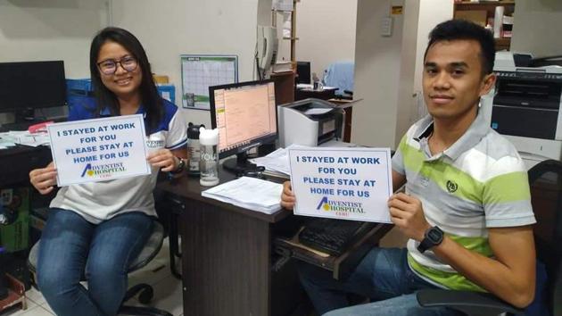 Two medical workers holding placards urging people to stay home. (Twitter/@janneth_jcc) Two medical workers holding placards urging people to stay home. (Twitter/@janneth_jcc)