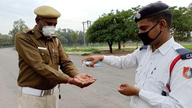 CoronavbiruPolice officials sanitize their hands at housing board light point in Chandigarh. (Ravi Kumar/HT Photo) CoronavbiruPolice officials sanitize their hands at housing board light point in Chandigarh. (Ravi Kumar/HT Photo)