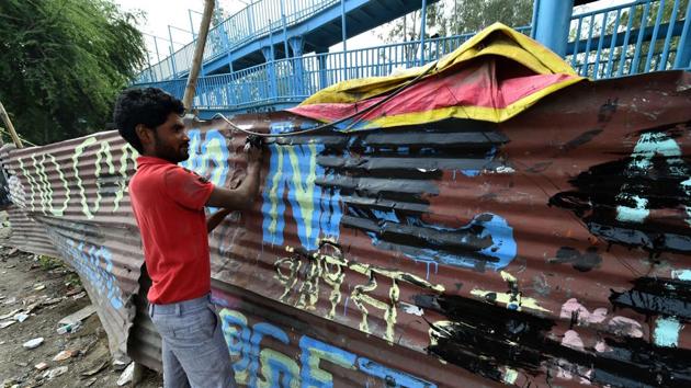 A man removes anti-CAA slogans at Shaheen Bagh. (PTI)