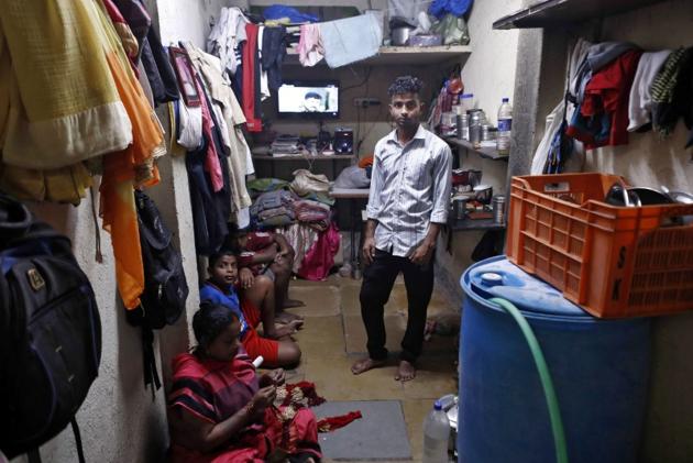 Ajay Kewat, a bank employee, poses for a photograph inside his house in Mumbai. (reuters)