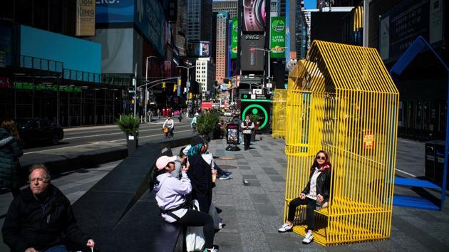 People enjoy the day as they walk around Times Square on March 21, 2020. The relaxation could be announced early next week when a 15-day period recommending tight restrictions on social distancing expires, he said, stressing that governors would make final decisions in their own states. (Eduardo Munoz / REUTERS)