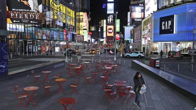 A woman walks through a lightly trafficked Times Square in New York. The attack rate in the region is close to one in 1,000, five times what other areas are seeing, Birx said at a Trump press briefing. About 28% of the submitted tests are positive, compared with less than 8% in the rest of the country, she said. (Seth Wenig / AP)