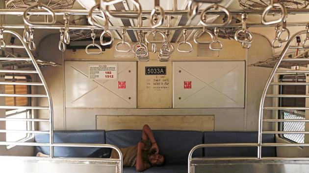 A railway employee talks on the phone inside an empty train compartment after railway services were shutdown by the authorities to limit the spread of the coronavirus disease (COVID-19) in Mumbai. (REUTERS)