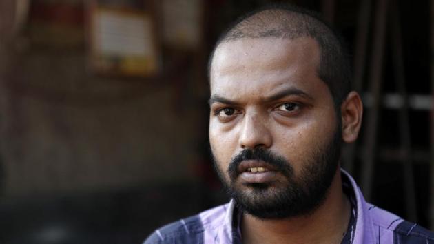 Shaikh Bahaduresha, a taxi driver, poses for a photograph on a street in Mumbai. (REUTERS)